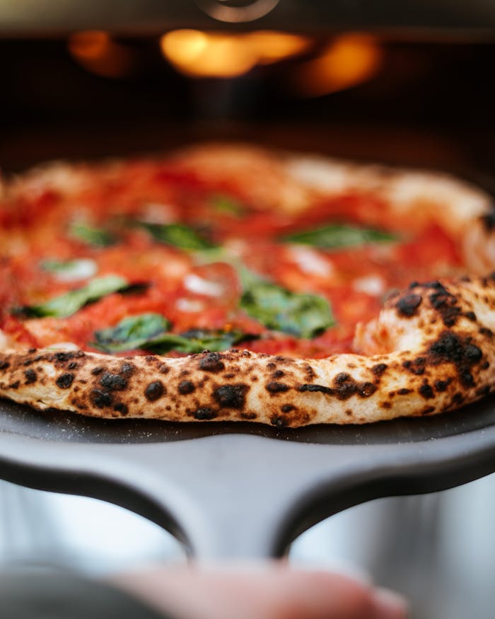 Close-up of a fresh Neapolitan pizza with vibrant toppings and a crispy crust straight from the oven.